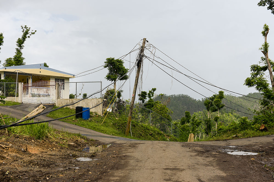 A hurricane-damaged house and power lines in Puerto Rico